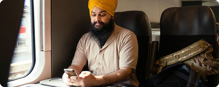 Person holding a phone while traveling on a train.