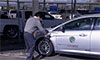 Photo of a man charging a car.