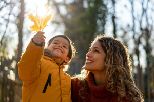 A mom and child outdoors in the fall