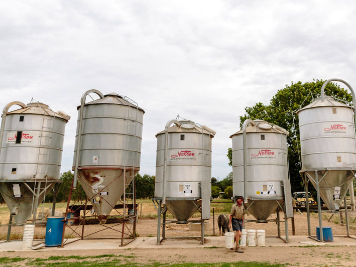 Group of silos with farmer in front