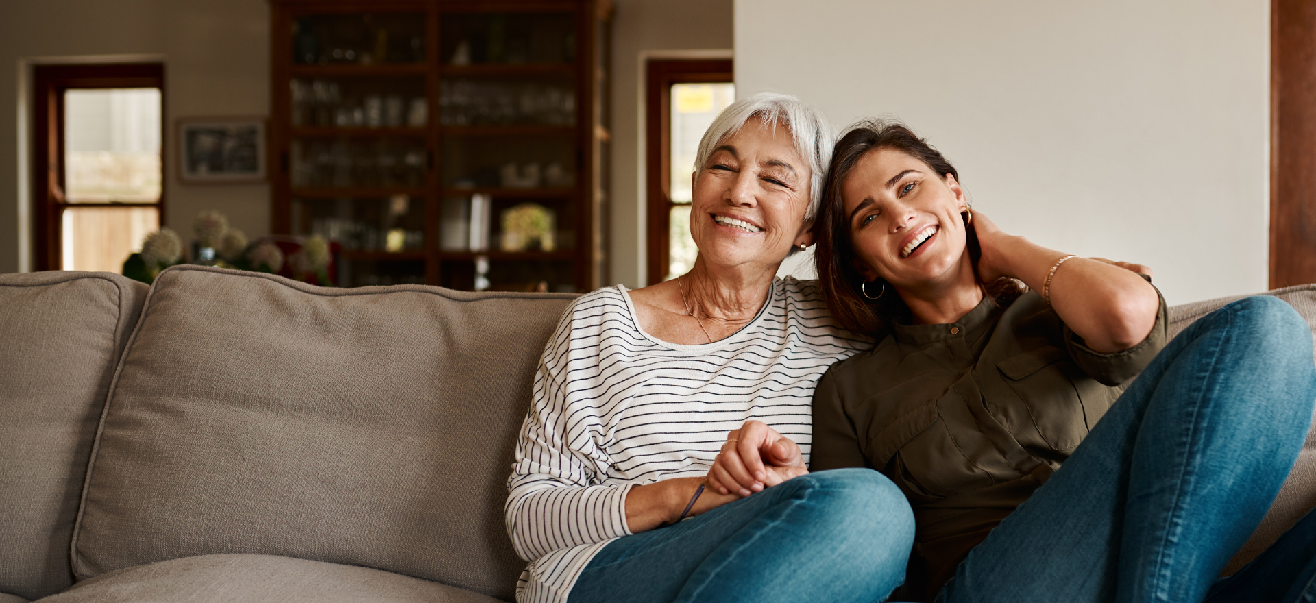 Mother and daughter hugging on a couch