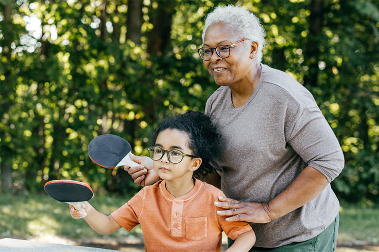 Woman plays table tennis with granddaughter