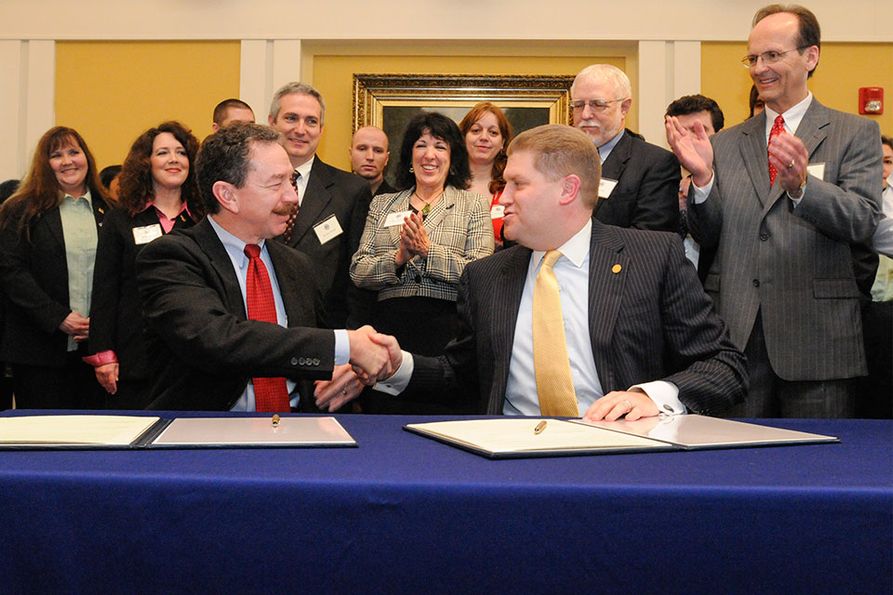 WVU President Mike Garrison shakes hands with FBI official