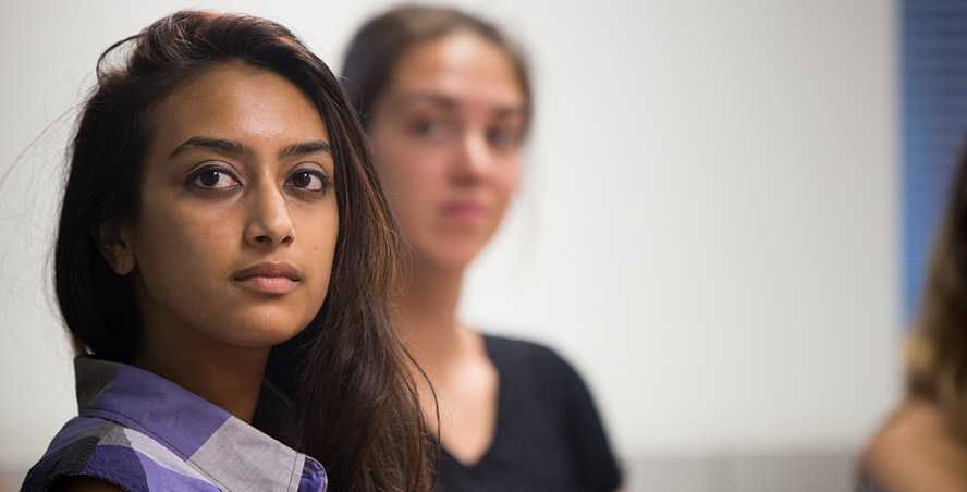 Photo of a Case Western Reserve University student looking at the camera, with another student in the background out of focus