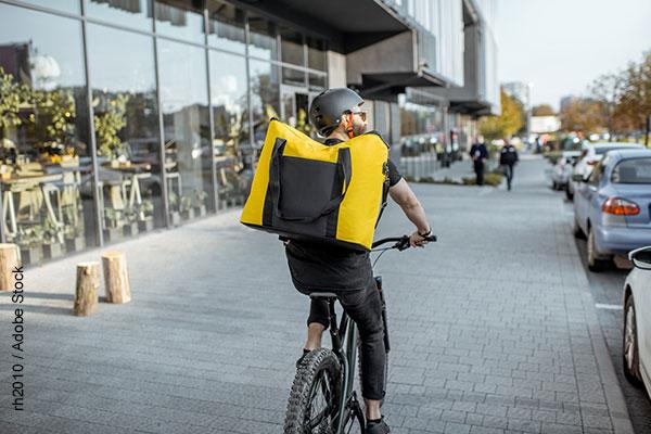 Young bearded courier delivering food