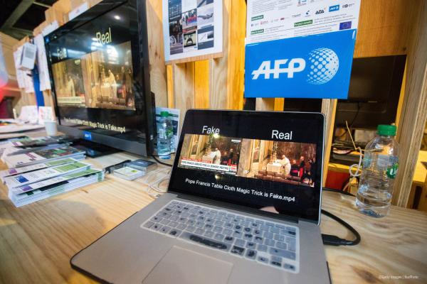 A laptop displaying both fake and real versions of a video.