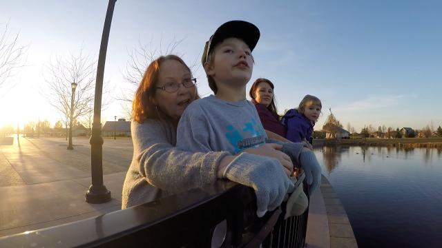 Grandmother with her grandchildren looking out over a lake or river