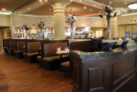 View of the booths in the main dining room. The main dining room features high ceilings, majestic columns with period cornice moldings, large wall-to-wall windows and hardwood floors. 