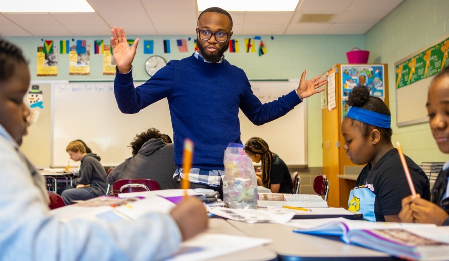 Image of Black teacher resident giving a lesson in the classroom. 