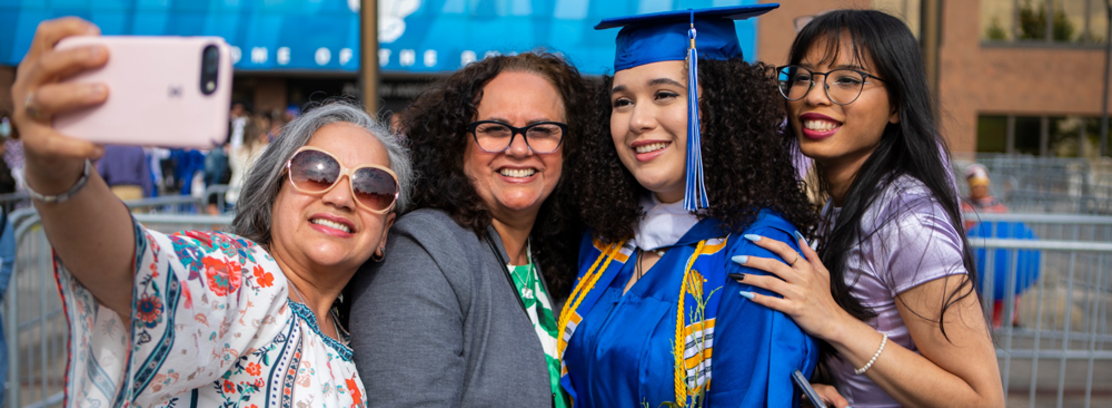 Photo of graduate after commencement outside Alumni Arena. 