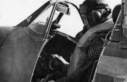 A sergeant pilot of the British Royal Air Force sits in the cockpit of his Spitfire in September 1940. IWM (HU 104502)