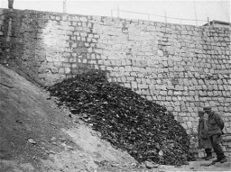 After the liberation of the Flossenbürg concentration camp, two US army infantrymen examine a pile of shoes belonging to victims ... [LCID: 77028]