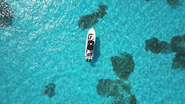 aerial view of a small boat on shallow bright blue water