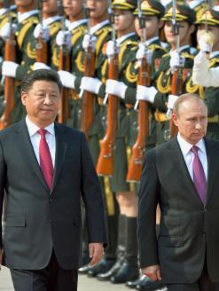 Chinese President Xi Jinping (L) and Russian President Vladimir Putin attend a welcome ceremony for Putin at the Great Hall of the People in Beijing on June 25, 2016. Editorial Credit: Kyodo News Stills via Getty Images.