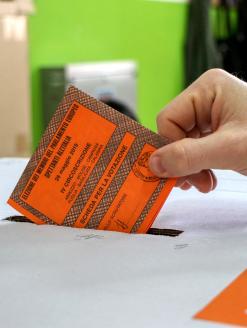 A man inserts the inserts a voted ballot into the ballot box. Puglia, Italy. 26 May 2019. Editorial Credit: Editorial credit: Massimo Todaro / Shutterstock.com