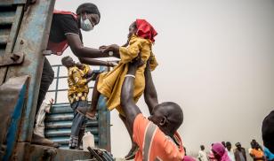 A child is loaded into a truck taking people fleeing from Joda on the Sudanese border