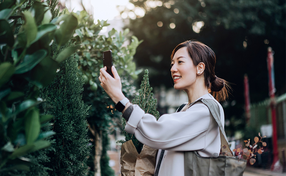 花市場で植物の写真を撮っている女性