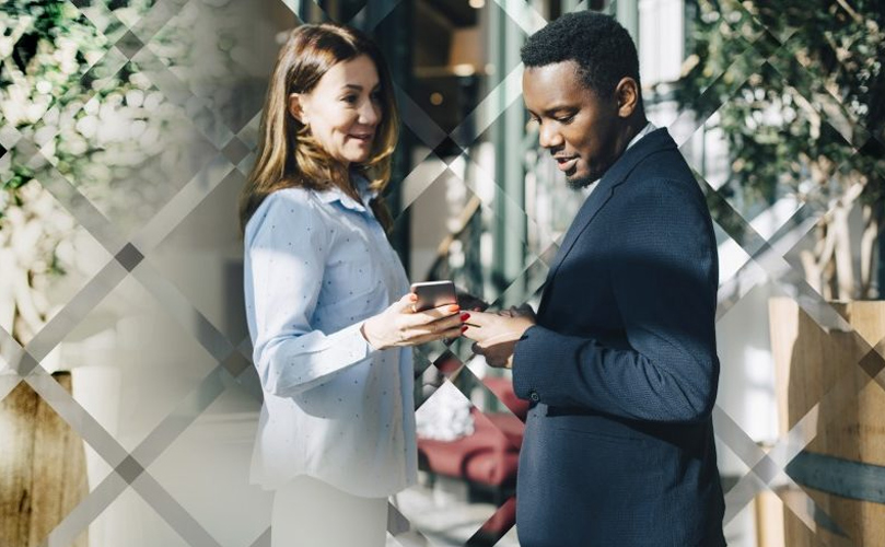 Un homme et une femme en plein air regardant un téléphone