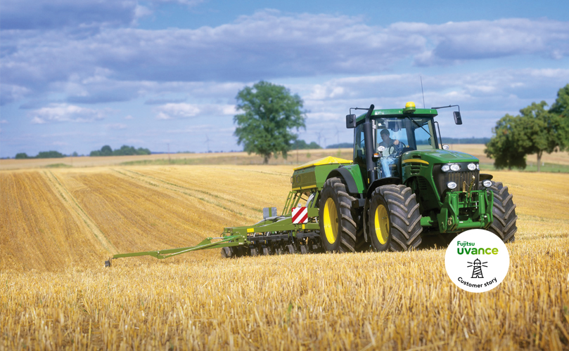 A man riding a tractor in the middle of a corn field