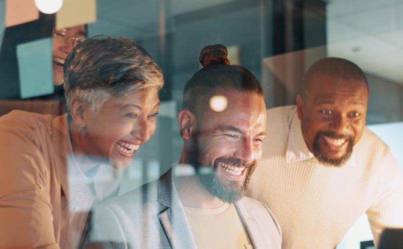 Three people laughing looking at something that's not in frame