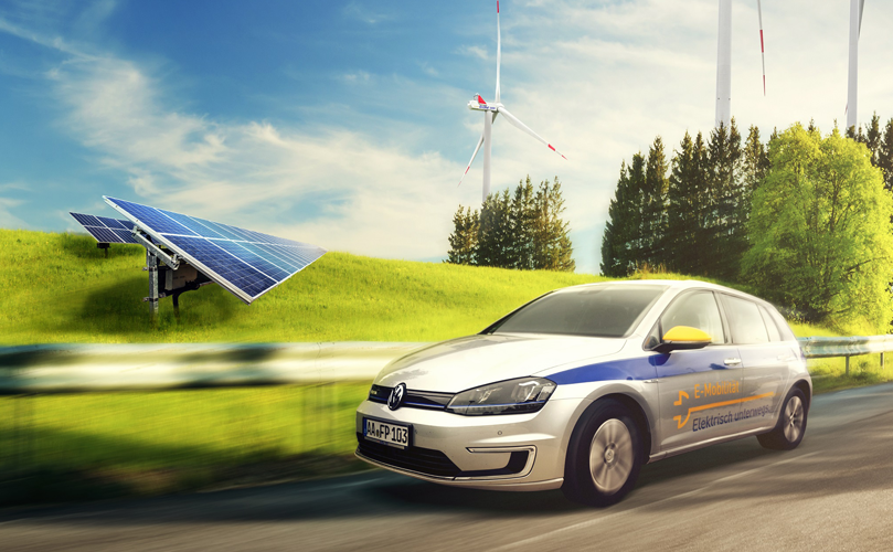 An electric vehicle on the road passing though a green field with a solar panel