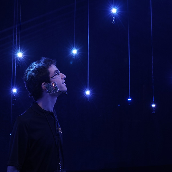 Student surrounded by LED string lights