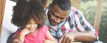 a father reading with his daughter