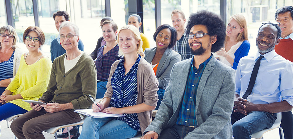 A diverse group of students smiling in a bright classroom