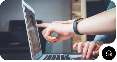 two persons pointing at a laptop's screen