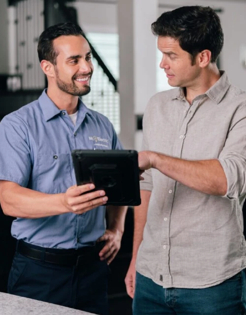 Mr. Electric electrician showing tablet to customer.