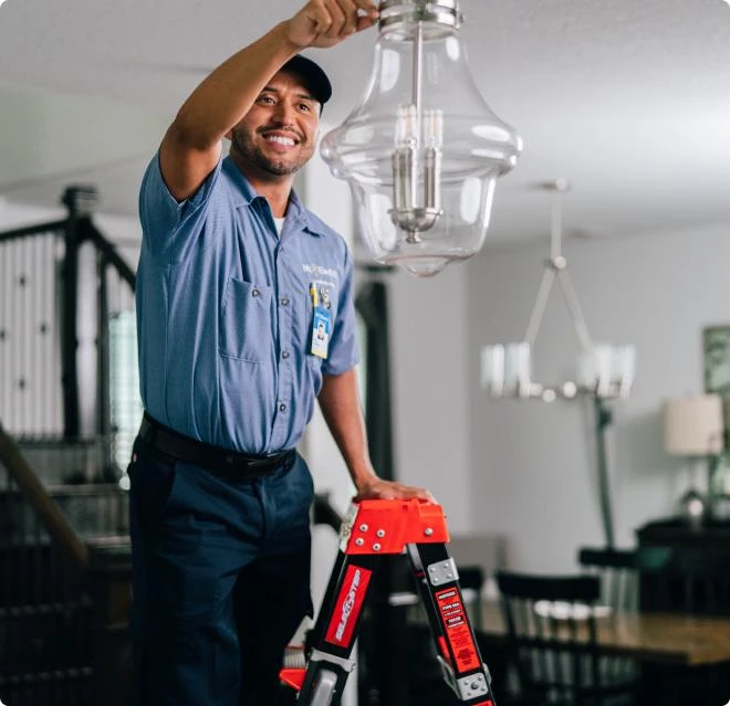 Electrician adjusting chandelier. 