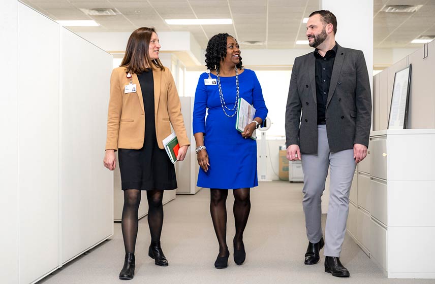 Two Cleveland Clinic caregivers and an applicant walking through an office building.