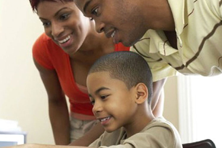 Two parents working with their son on school work