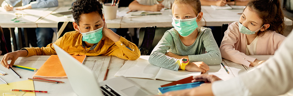 Students weaering masks in school at desks