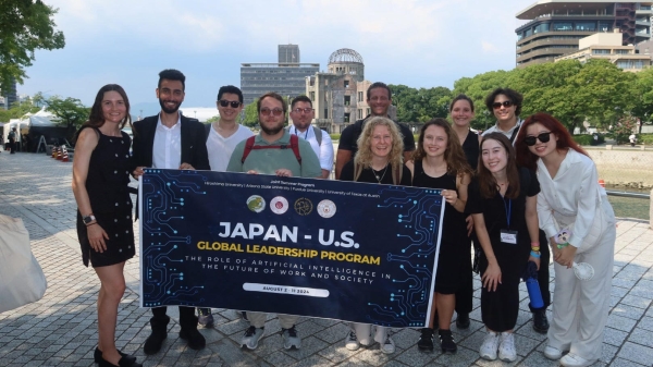 A group poses for a photo holding a sign reading "Japan - U.S. Global Leadership Program"