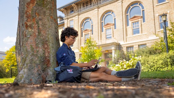 A CALS student works outside on the Ag Quad.