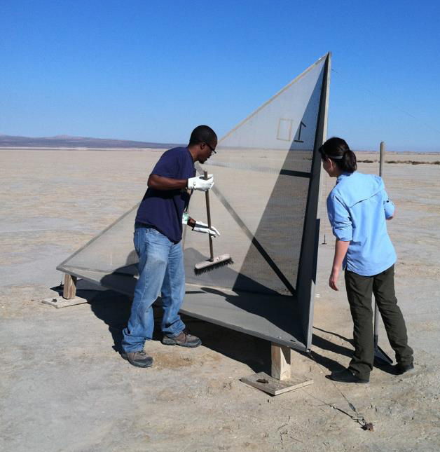 two people standing next to a corner reflector