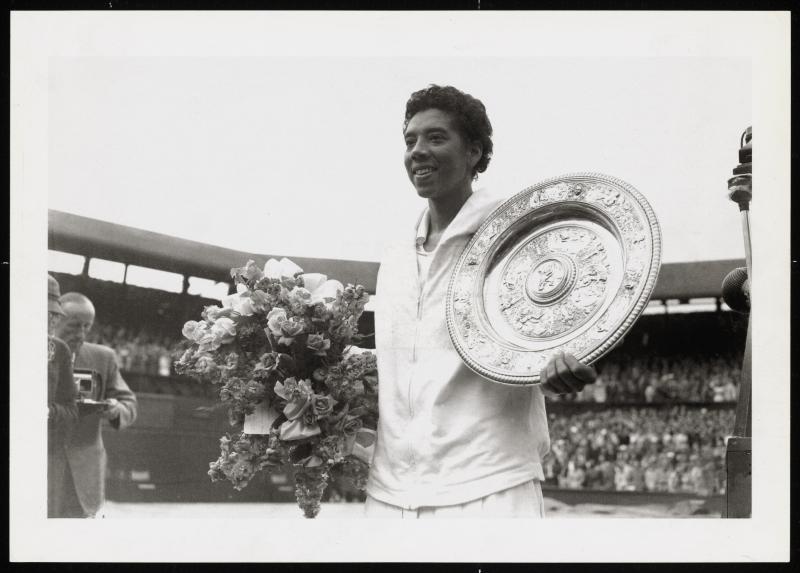 Image of Althea Gibson holding flowers and a championship trophy.