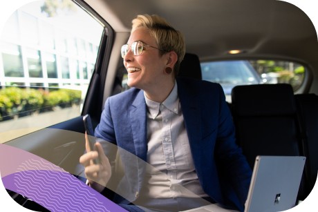 Person holding a laptop while looking out the window of a car