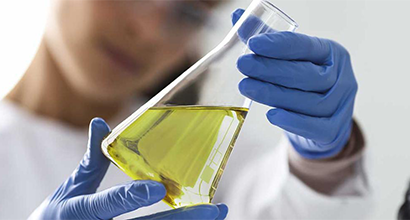 Scientist with blue gloves holding test tube.