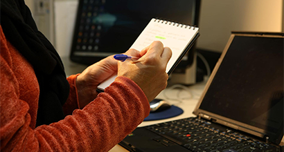 Woman taking notes on notebook in front of notebook