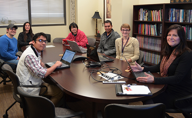 Students and professor seated at conference table