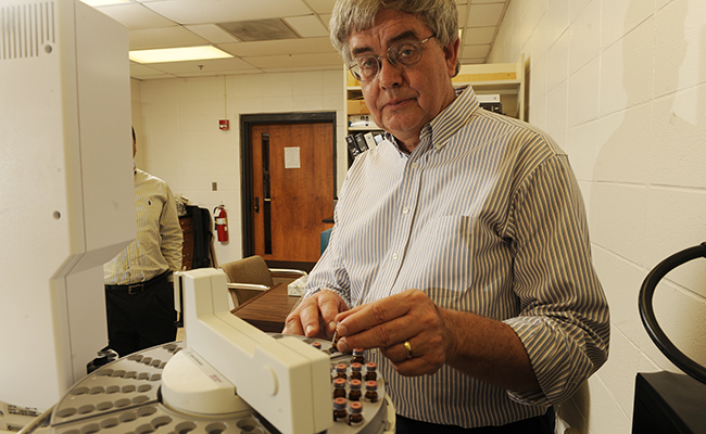 Professor stands over a centrifuge