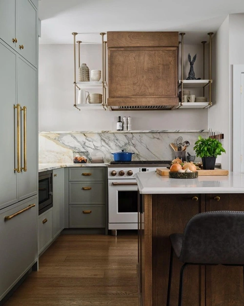 Marble backsplash and muted green kitchen cabinets