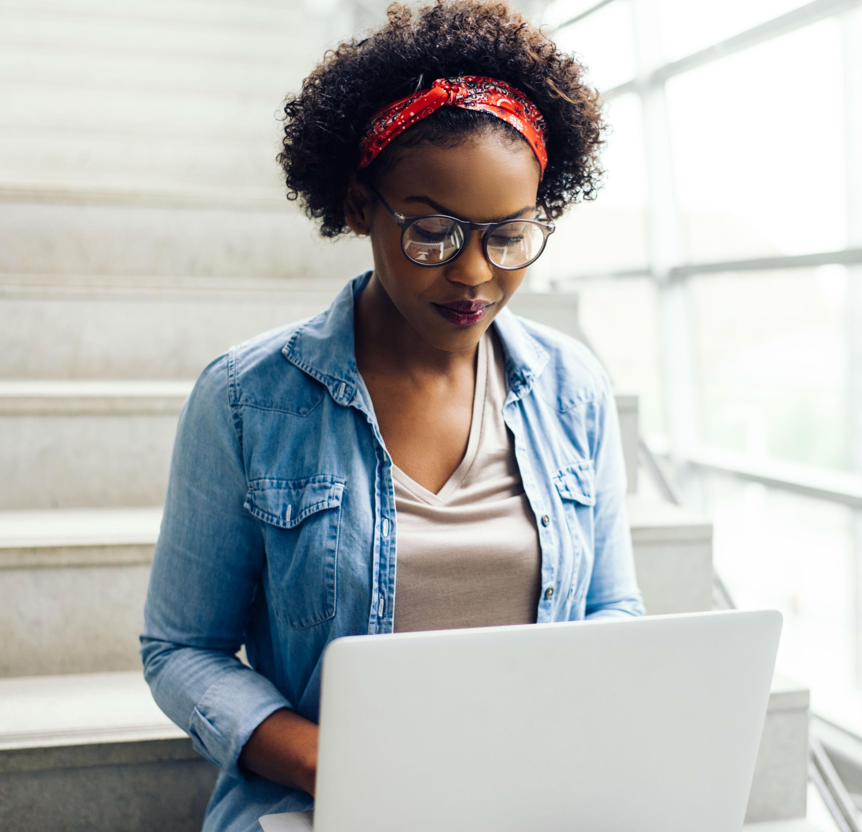 Mulher usando um laptop sentada em uma escada