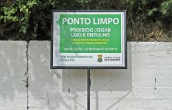 Placa à frente de mudo pintado com os dizeres: Ponto Limpo - proibido jogar lixo e entulho.