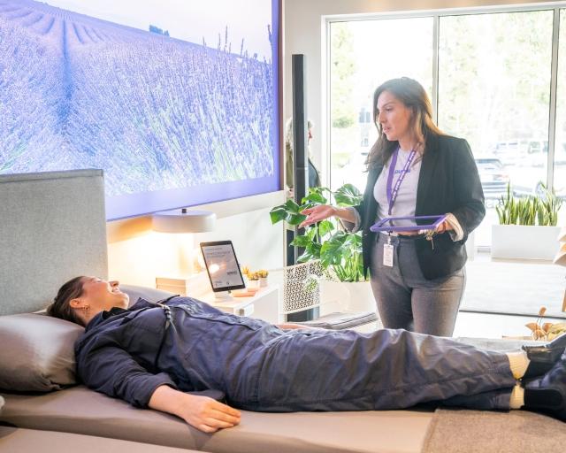 woman laying on mattress in showroom