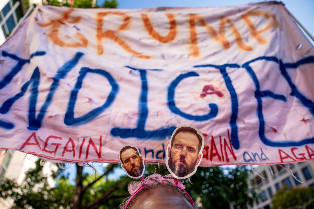 A demonstrator wears a headband with images of special counsel John L. "Jack" Smith as she waits outside a hearing on former President Donald Trump's election interference case Thursday in Washington. 