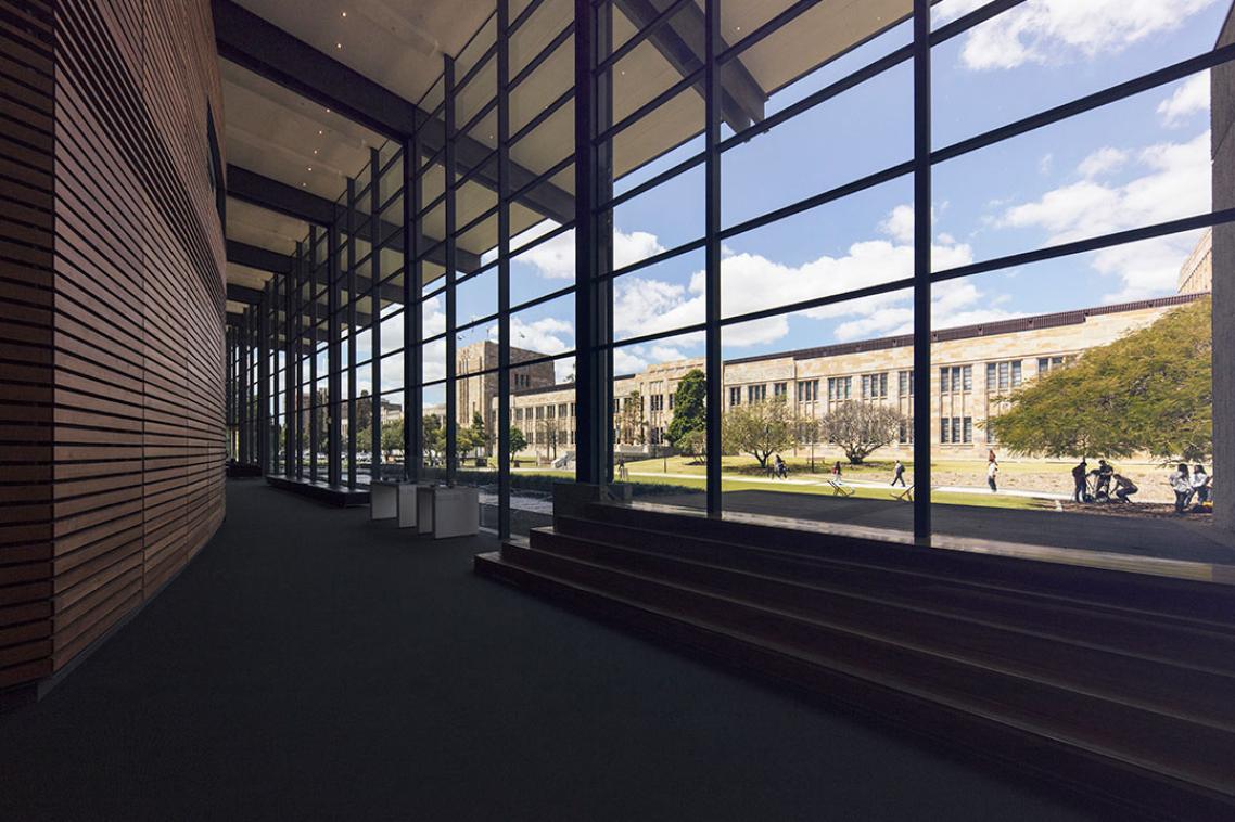 The sandstone exterior of the Forgan Smith building, as seen from glass, wood and steel interior of the UQ Art Museum. 