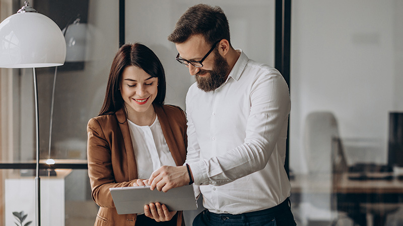 Woman using tablet that man is holding in hands